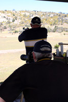 A shooter takes aim while his spotter looks on.